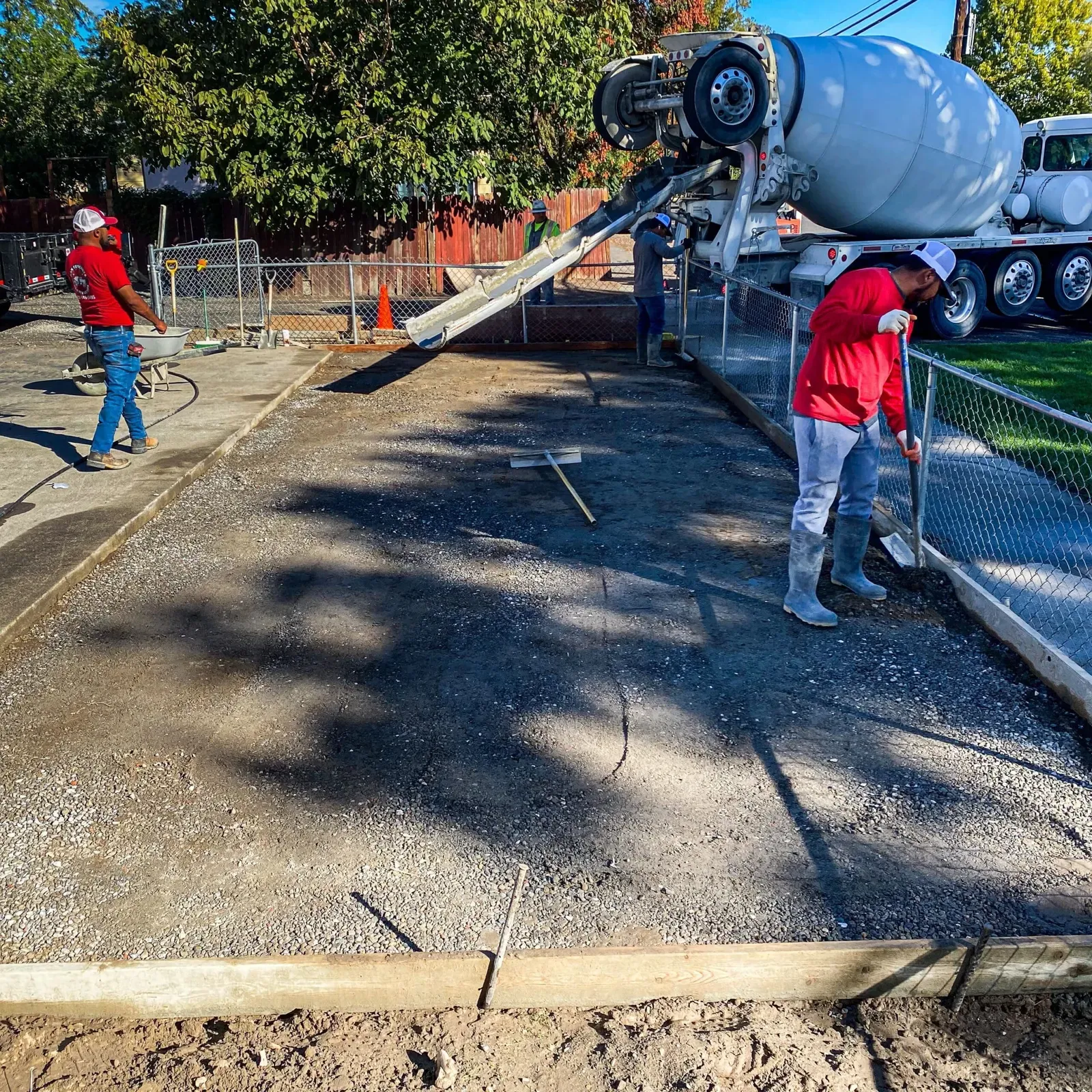 H&N Concrete crew guiding a mixer-truck chute during a fresh driveway pour