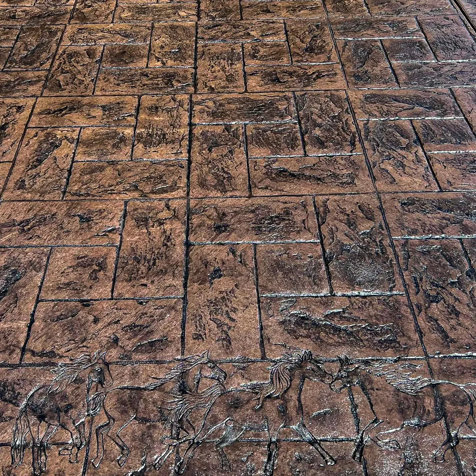 Close-up of stamped concrete in a dark stone-and-wood pattern