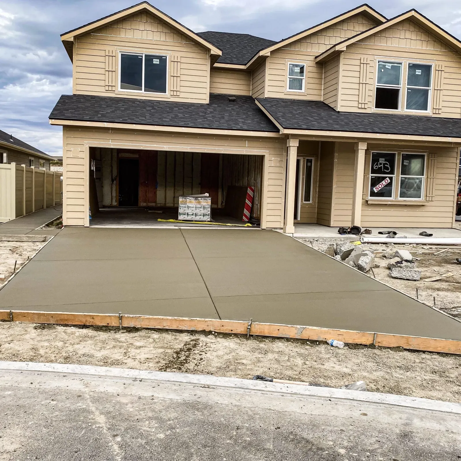 New two-story home with a freshly poured concrete driveway
