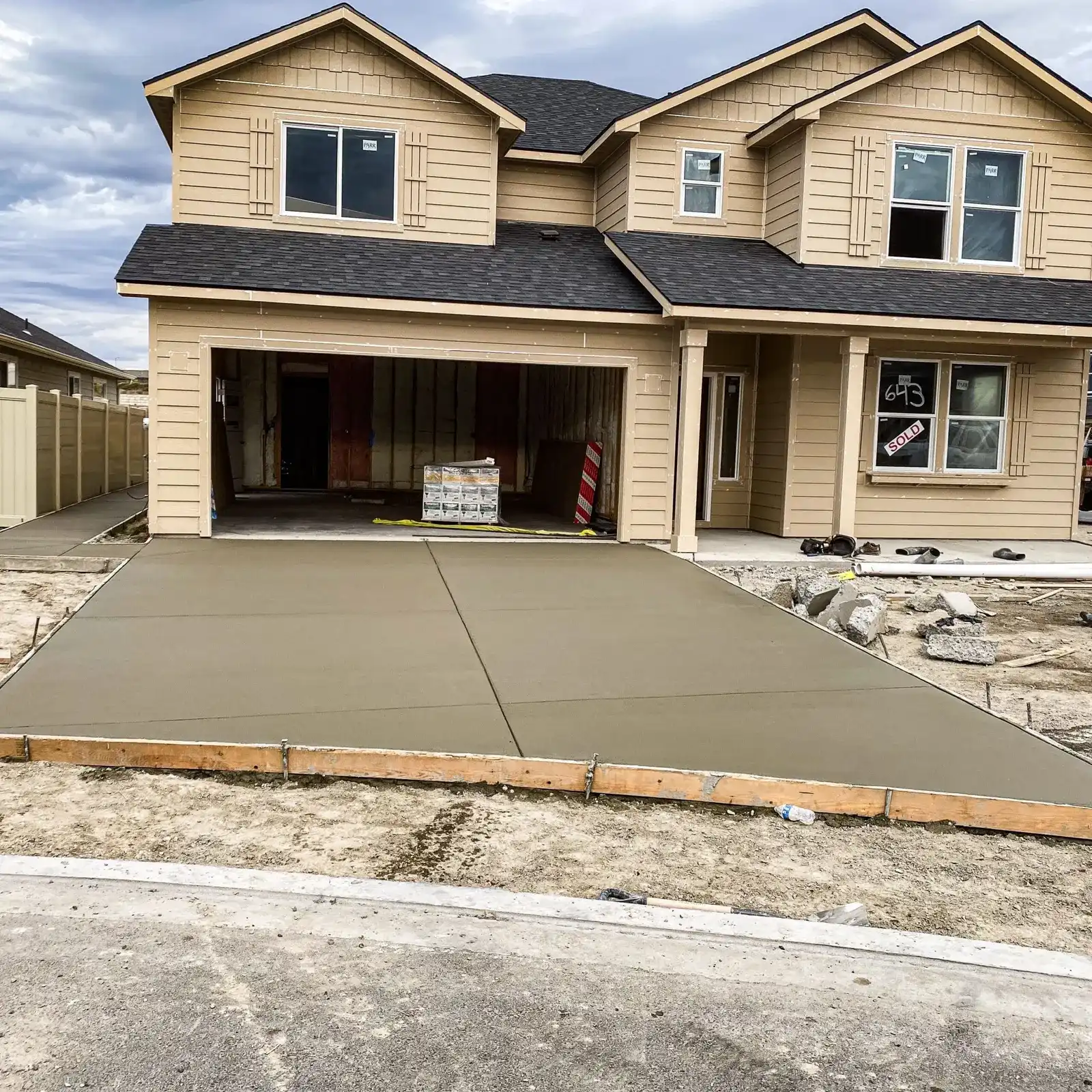 New two-story home with a freshly poured concrete driveway