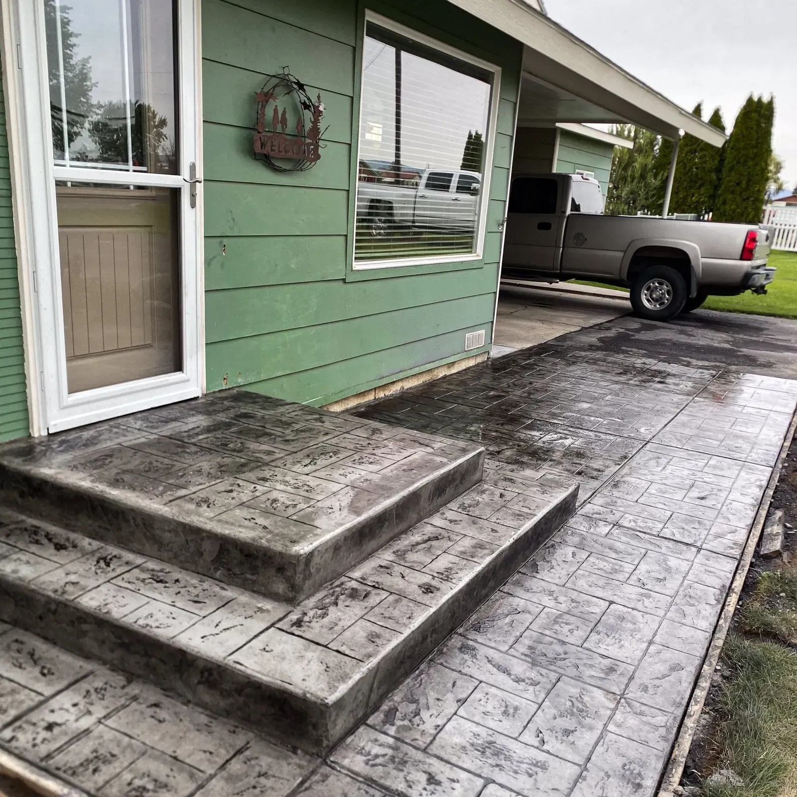 Stamped concrete front steps and walkway in a dark slate finish