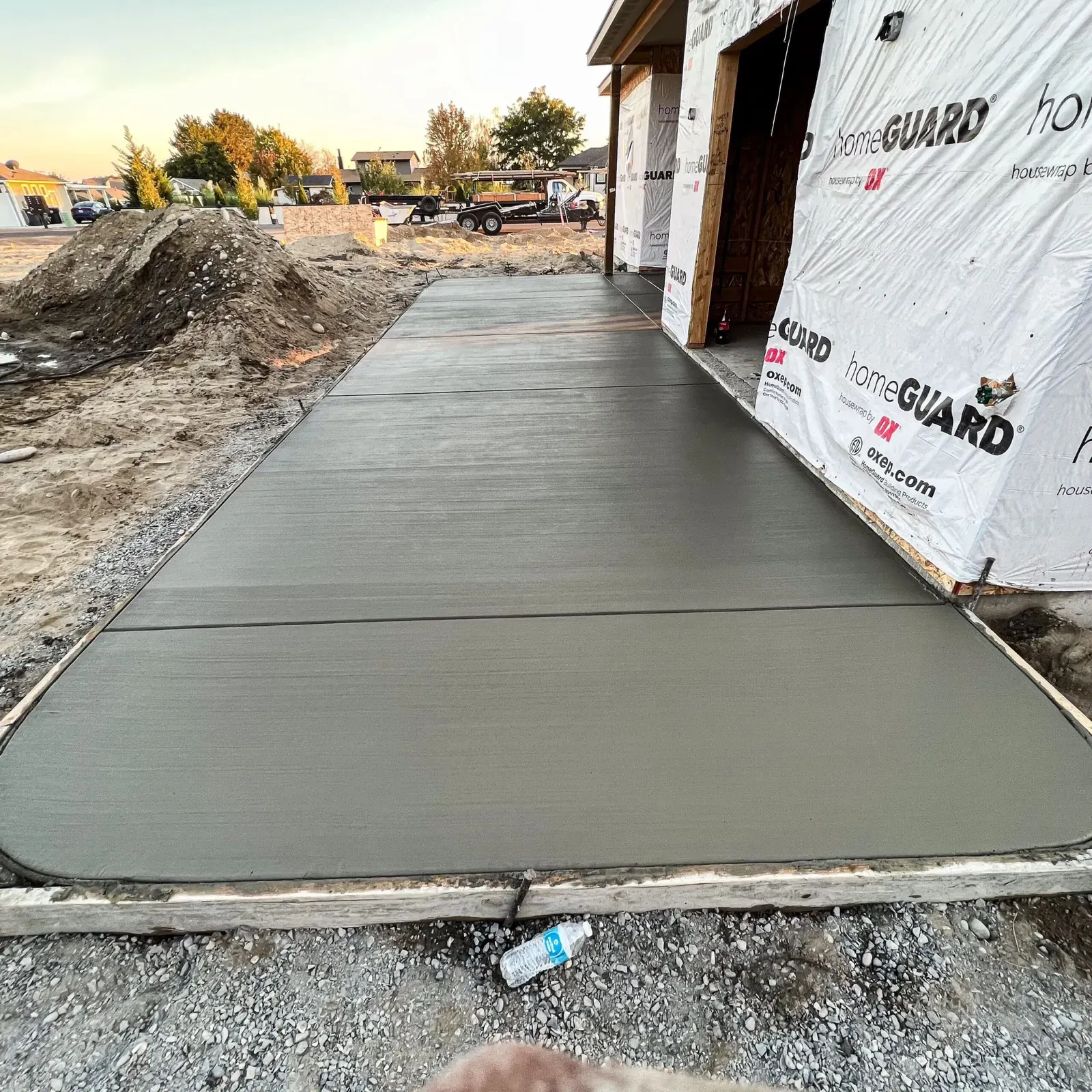 Fresh concrete walkway poured along a home under construction