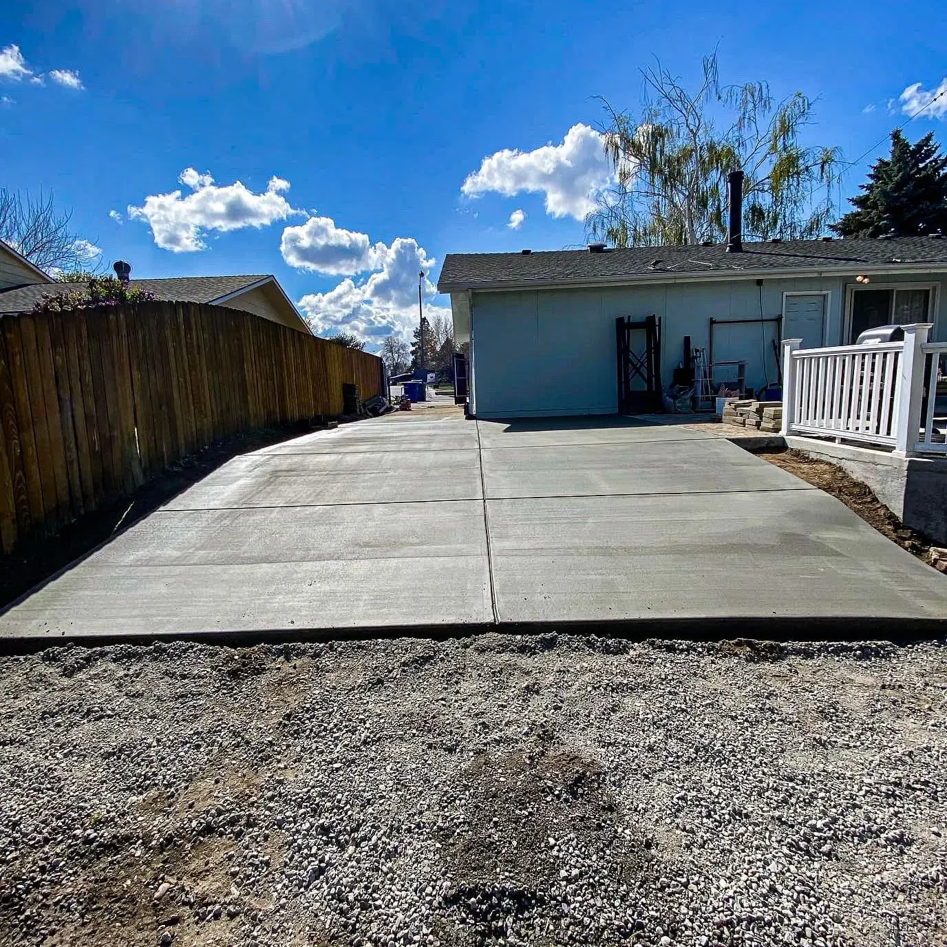 Long freshly poured driveway leading to a backyard garage