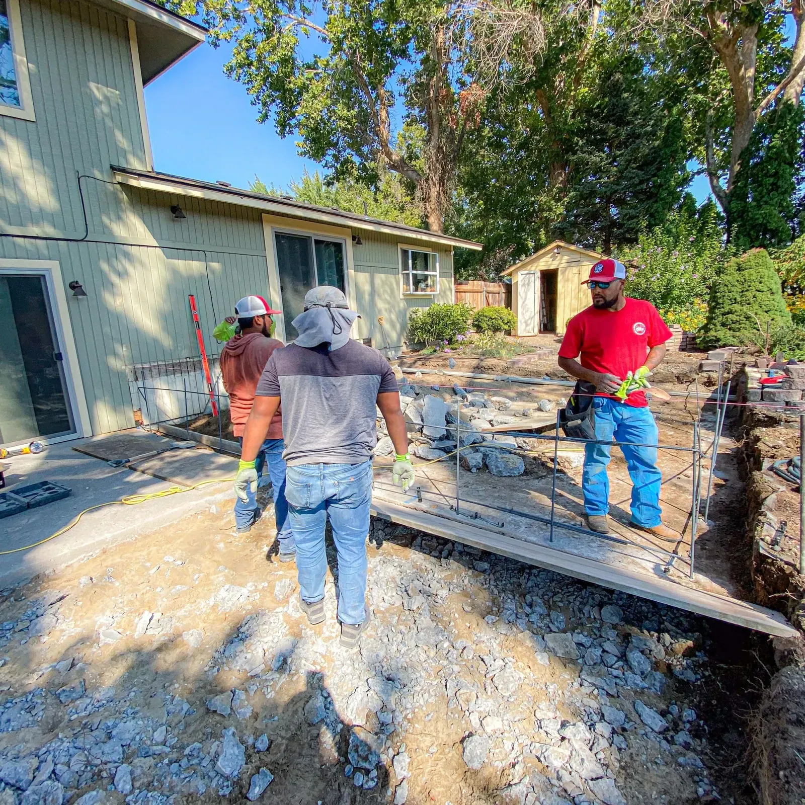 Crew removing an old concrete walkway before the replacement pour