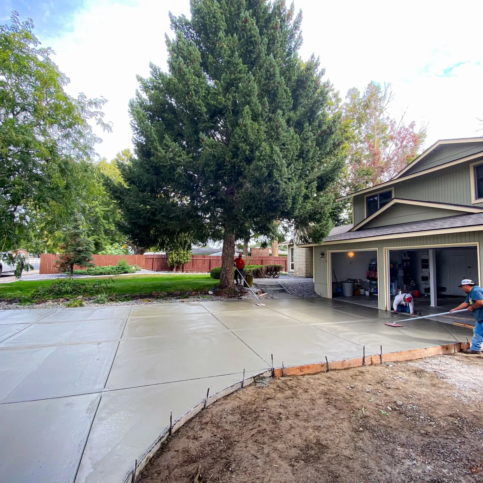 Freshly poured driveway extension in a mature shaded yard