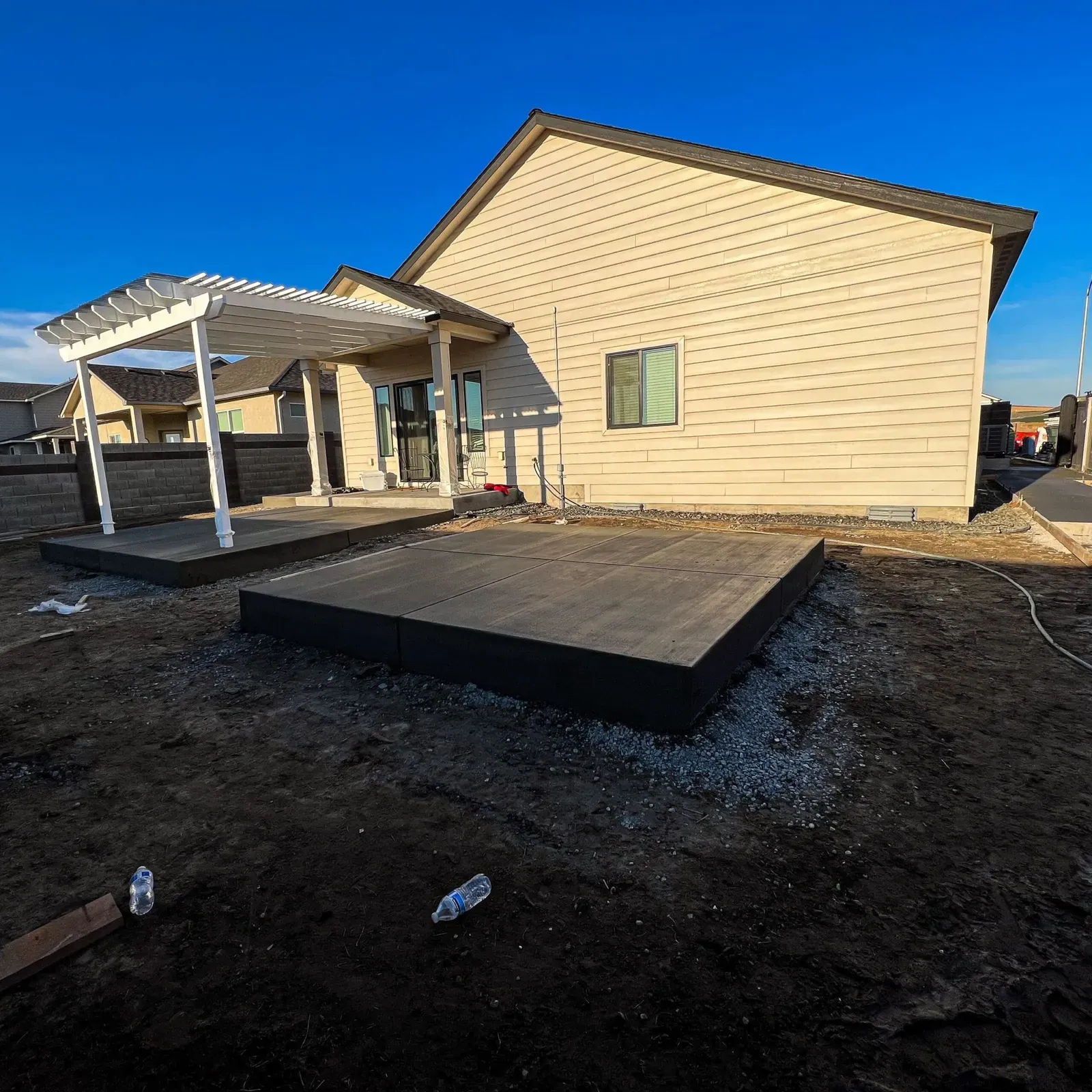 New backyard patio pad poured beneath a pergola