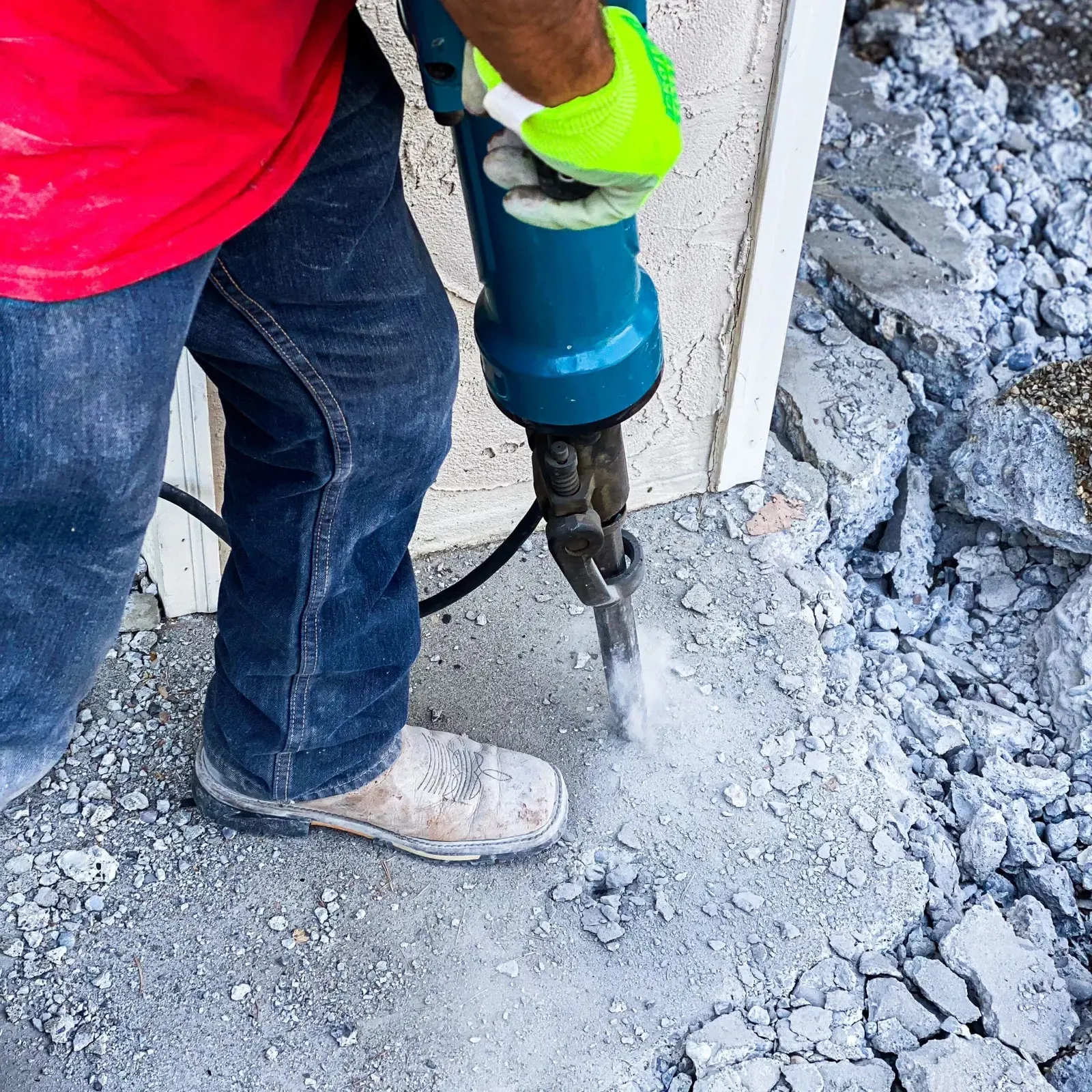 Close-up of a crew member jackhammering damaged concrete