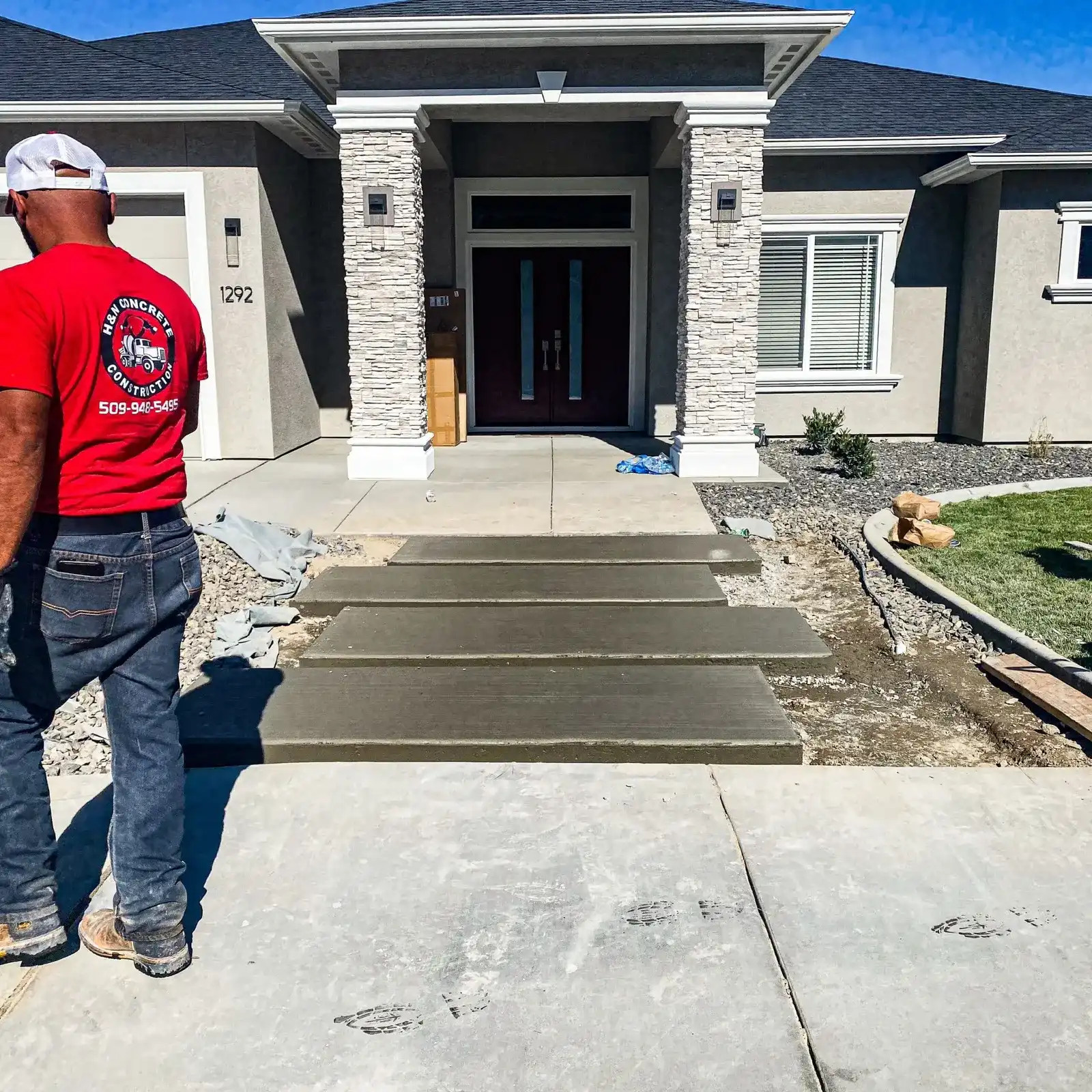 H&N Concrete crew member in a branded shirt finishing new front steps